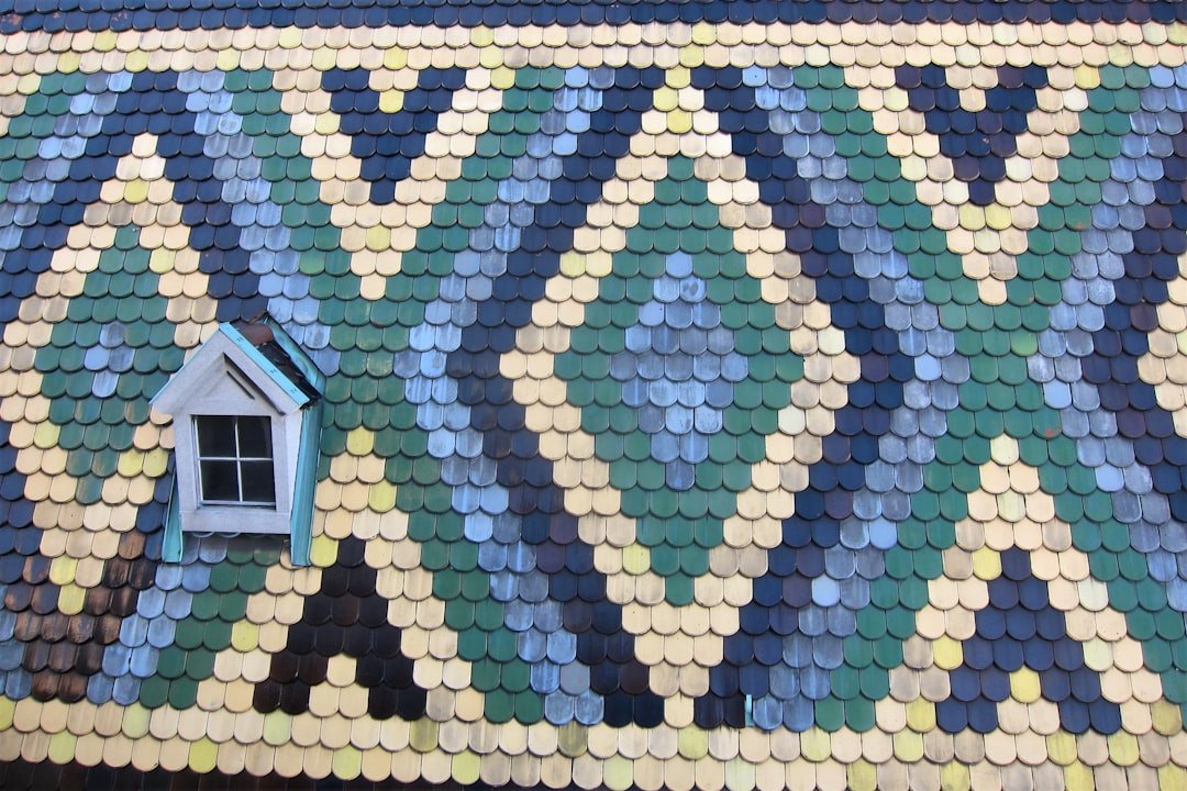 A miniature model of a house sits next to a growing stack of coins on a clean background, symbolizing the increase of home equity and financial investment.