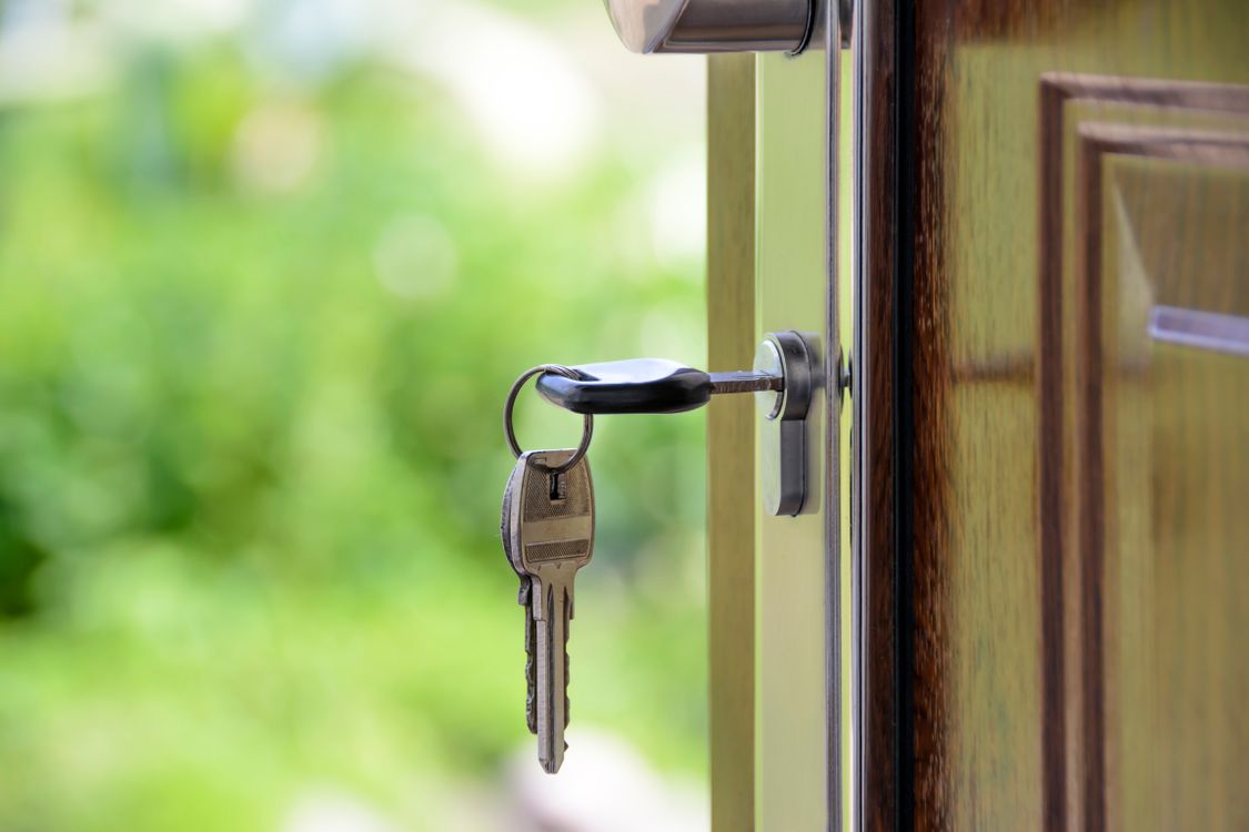 Teacher with a tote bag walks down a city street lined with classic Baltimore row homes after a day of work, looking thoug...